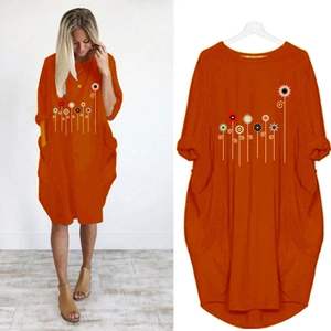 Detail view of caramel orange cotton tunic dress with artistic floral print and side pockets