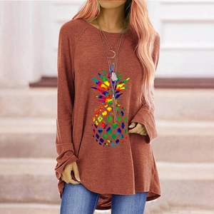 Close-up of a casual brick red long sleeve top featuring a colorful pineapple graphic