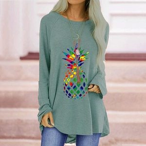 Detail view of colorful pineapple print and raglan sleeves on sage green t-shirt