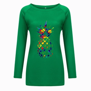 Close-up of a green long sleeve T-shirt with colorful pineapple print and size M tag