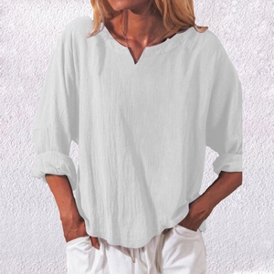 Close-up of a white cotton linen V-neck shirt with roll-up sleeves and natural texture