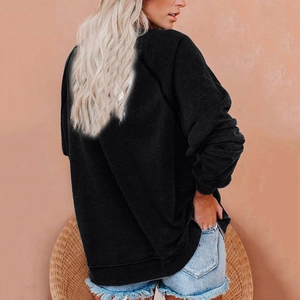Détail du sweat-shirt noir oversize avec manches raglan et finition texture tricotée