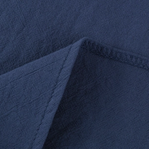 Detailed close-up of dark blue linen-cotton fabric showing neat stitching and texture