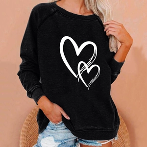 Close-up of double heart print on a black long sleeve sweatshirt with ribbed texture