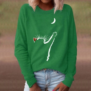 Close-up of emerald green long-sleeve sweatshirt featuring white cat and moon print