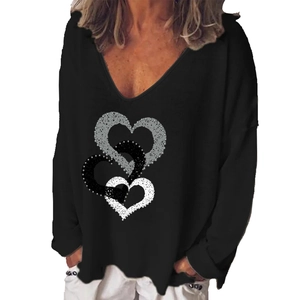 Close-up of interlocking heart pattern with dots on a black V-neck long sleeve shirt