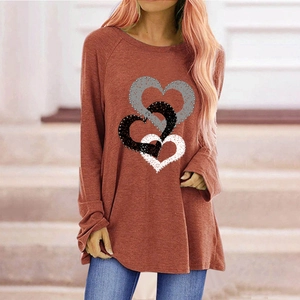 Detail of red long sleeve shirt featuring triple heart print and textured dot patterns