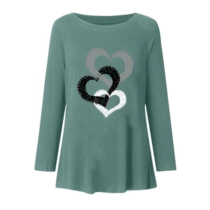 Detailed view of triple heart prints with textured weave on green long sleeve t-shirt