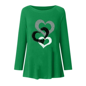 Detail of three textured heart prints on a loose green long-sleeve T-shirt for women