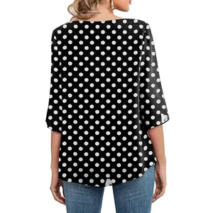 Back view of elegant black and white polka dot tunic with curved hem and 3/4 sleeves