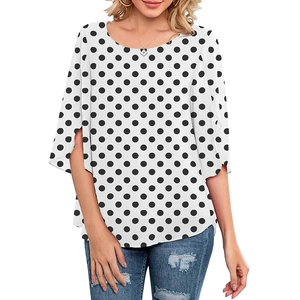 Detail of white polka dot top showing flared split sleeves and lightweight fabric texture