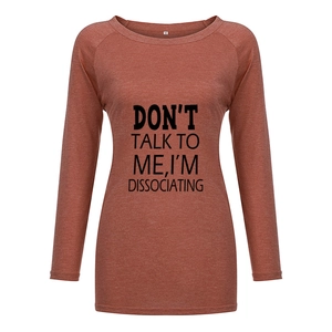 Détail d'un t-shirt rouge brique à manches longues avec imprimé noir et col rond évasé