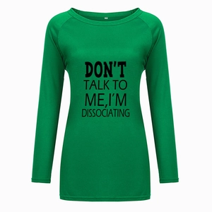 Gros plan sur l'imprimé texte noir d'un t-shirt à manches longues vert émeraude