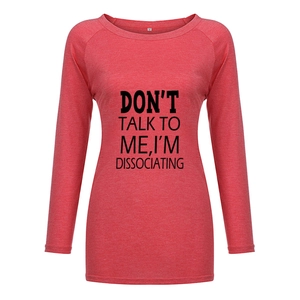 Détail du t-shirt rouge chiné montrant l'imprimé texte noir et le col rond doux
