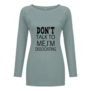 Gros plan sur l'imprimé à lettres d'un t-shirt gris-vert à manches longues raglan