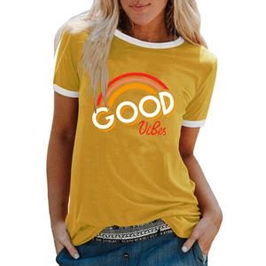 Détail du t-shirt jaune moutarde avec imprimé arc-en-ciel et lettrage GOOD VIBES