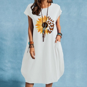 Détail de la robe en coton blanc avec imprimé tournesol et papillon et poches latérales