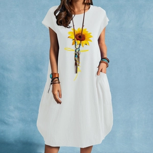 Detail of white cotton linen dress with sunflower print and side pocket features