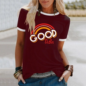 Vue macro de l'imprimé arc-en-ciel GOOD VIBES sur t-shirt bordeaux avec bordure blanche