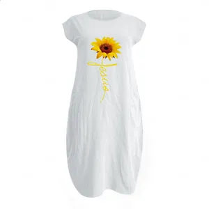 Detail of white cotton linen dress with sunflower print and Jesus script text