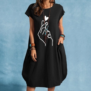 Détail d'une robe noire sans manches en coton avec imprimé cœur et poches latérales