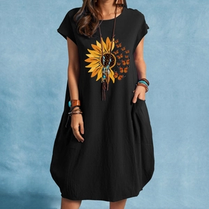 Détail de l'imprimé tournesol et papillon sur robe noire en coton et lin avec poche