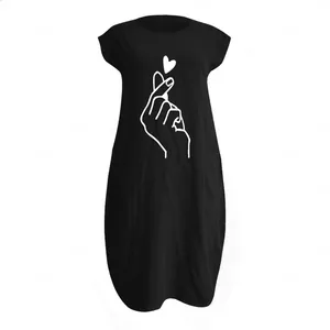 Détail d'une robe noire en coton et lin avec motif cœur de doigt blanc et col rond