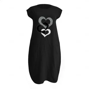 Détail de l'imprimé triple cœur sur une robe mi-longue en coton et lin noire