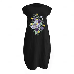 Detailed flat lay of a black floral linen dress featuring a purple pansy print and crew neck