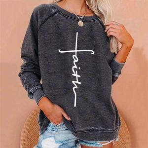 Detail of cross-shaped faith print on dark gray crewneck sweatshirt with raglan sleeves
