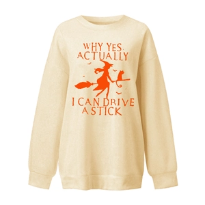 Détail du col côtelé et de l'imprimé sorcière sur balai sur un sweat-shirt de couleur crème