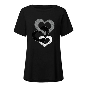 Détail de motifs cœurs superposés avec texture pailletée sur un T-shirt noir à manches courtes