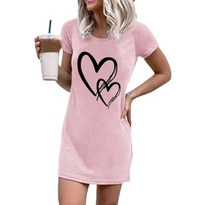 Detalle del vestido camiseta rosa con un estampado creativo de doble corazón negro y cuello redondo