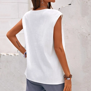 Detail of white cotton linen sleeveless top showing breathable texture and loose fit design