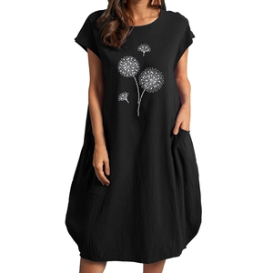 Detail des weißen Pusteblumen-Drucks und der praktischen Seitentaschen am schwarzen Kleid
