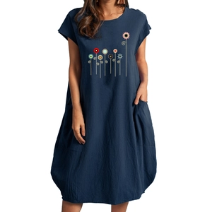 Detail of colorful floral embroidery and convenient side pocket on blue cotton linen dress