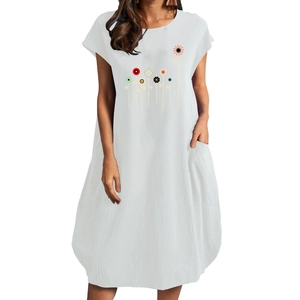 Detail of white cotton linen summer dress featuring colorful floral print and side pockets