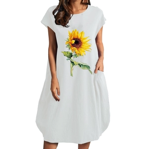 Detalle de un vestido blanco de algodón y lino con estampado de girasol y bolsillos