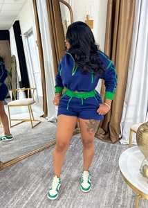 Detail of blue and green patchwork sporty set featuring half-zip collar and ribbed cuffs