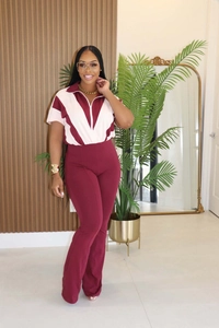 Détail du haut polo bordeaux et pantalon évasé avec coutures colorées en forme de V