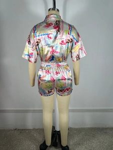 Vue arrière d'un pyjama en satin rose avec motifs tropicaux d'ananas et de palmiers
