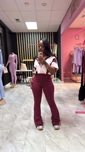 Détail du pantalon évasé bordeaux et du haut à col zippé sur un ensemble ajusté femme