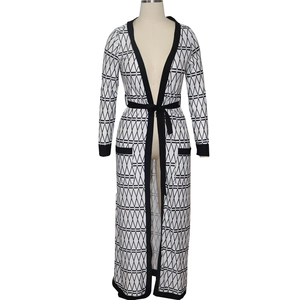 Close-up of geometric pattern on white long cardigan with black belt and cuffs