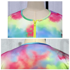 Detail of neon yellow zipper and vibrant tie-dye pattern on the neckline of the swimwear