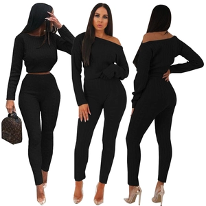 Detail of black off-shoulder knitted two-piece set with ribbed texture and slim fit design