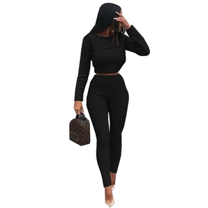 Detail of black cable-knit sweater set showing textured fabric and slim fit silhouette