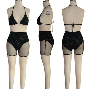 Detail view of black sequined two-piece set with mesh shorts and colorful rhinestones