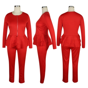 Détail d'un ensemble rouge deux pièces avec haut zippé à volants et pantalon ajusté