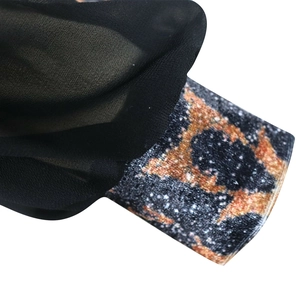 Vue macro du tissu en maille noire avec un patch décoratif scintillant à paillettes