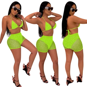 Neon green two-piece bikini set with high-waisted mesh shorts and sparkling polka dots